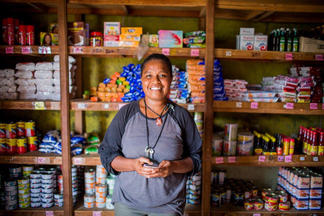 Female entreprenuer standing in a shop infront of the goods for sale