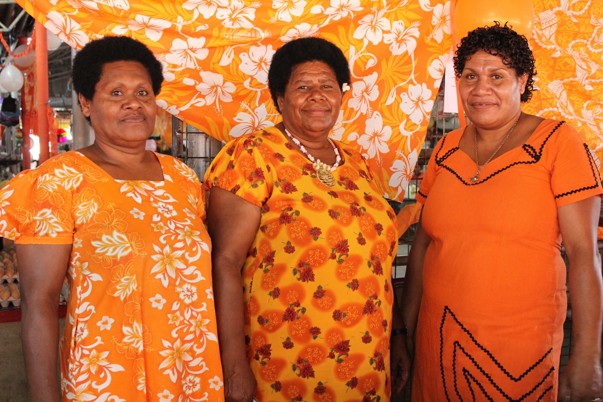 Pacific women wearing orange