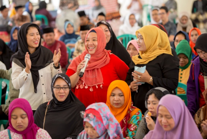 Women sharing her thoughts in a large group of women using a microphone