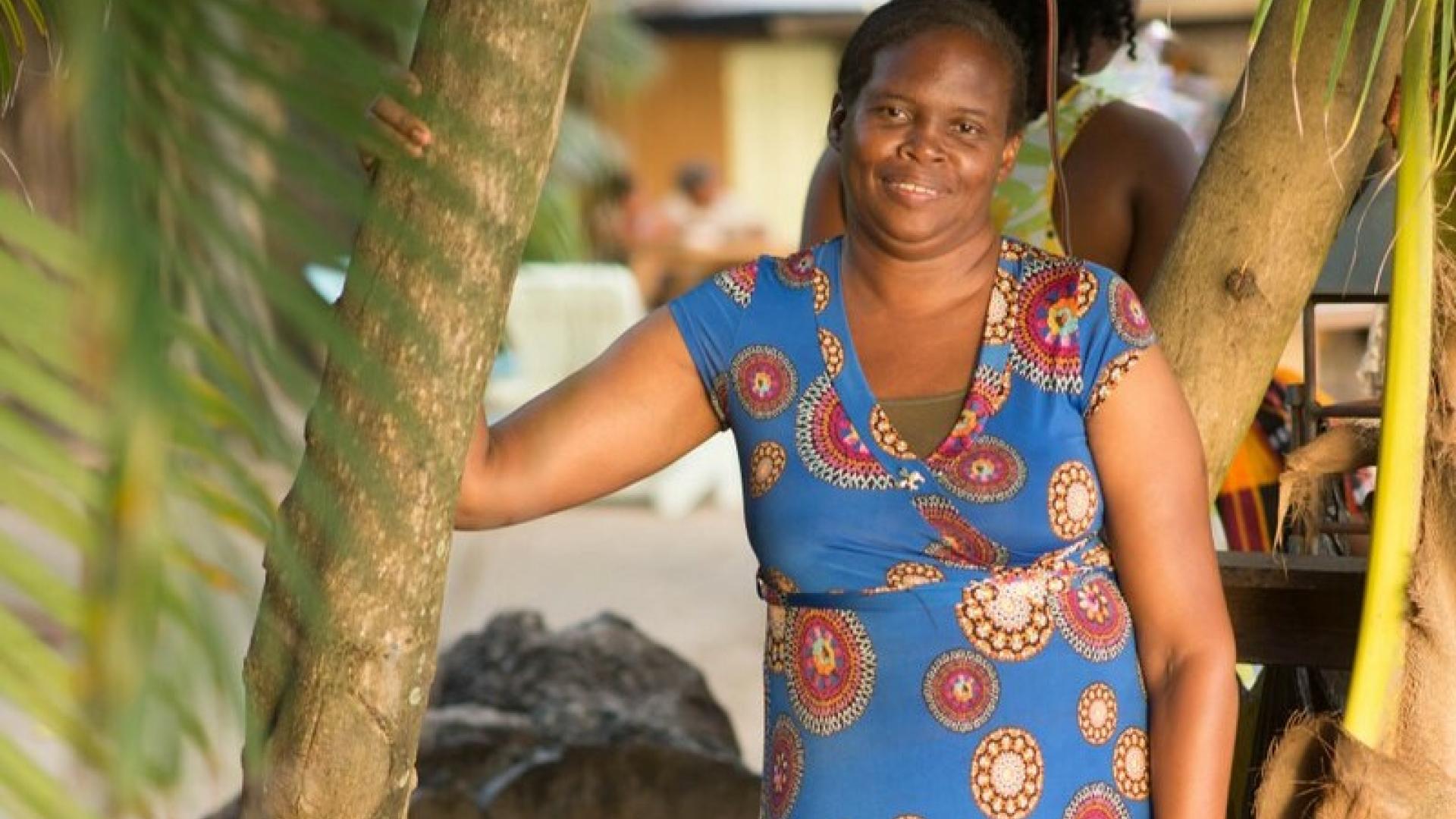 Women standing besides palm tree